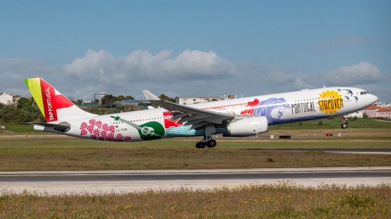 Avião em solo com vista panorâmica de uma cidade turística ao entardecer